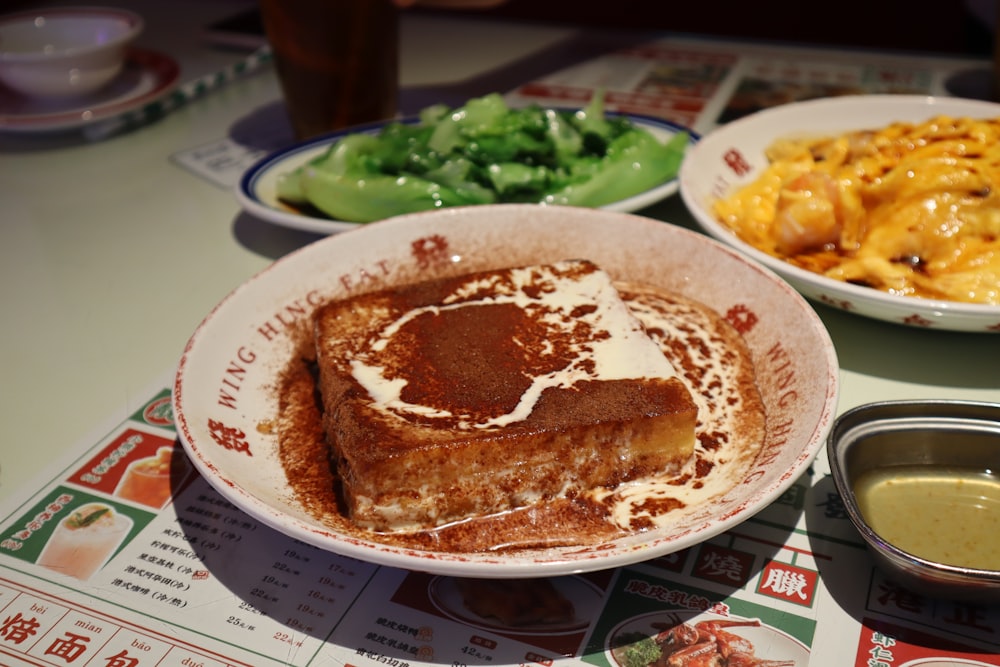 a table topped with plates of food and a bowl of macaroni and cheese