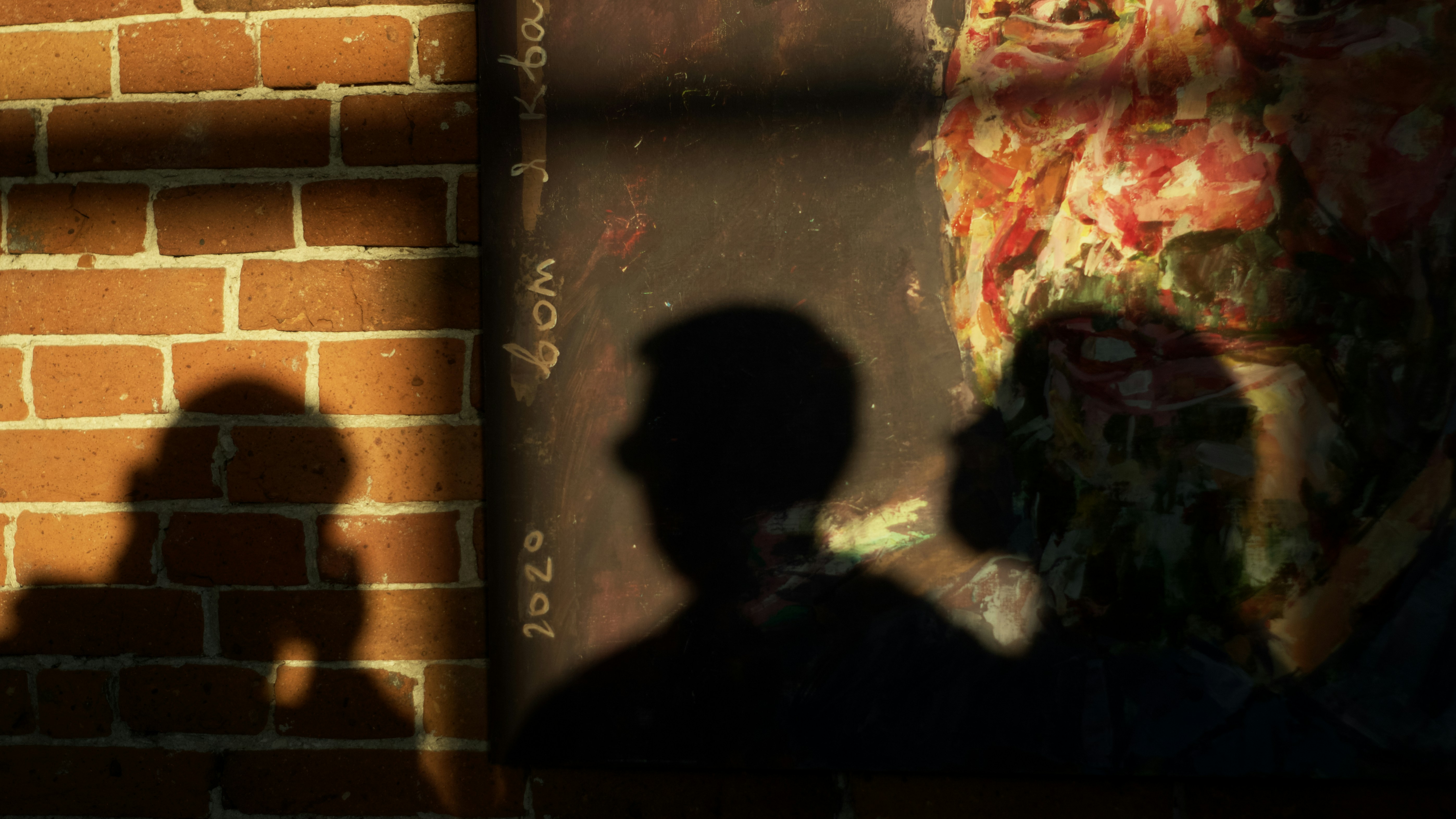 a shadow of a person standing in front of a brick wall