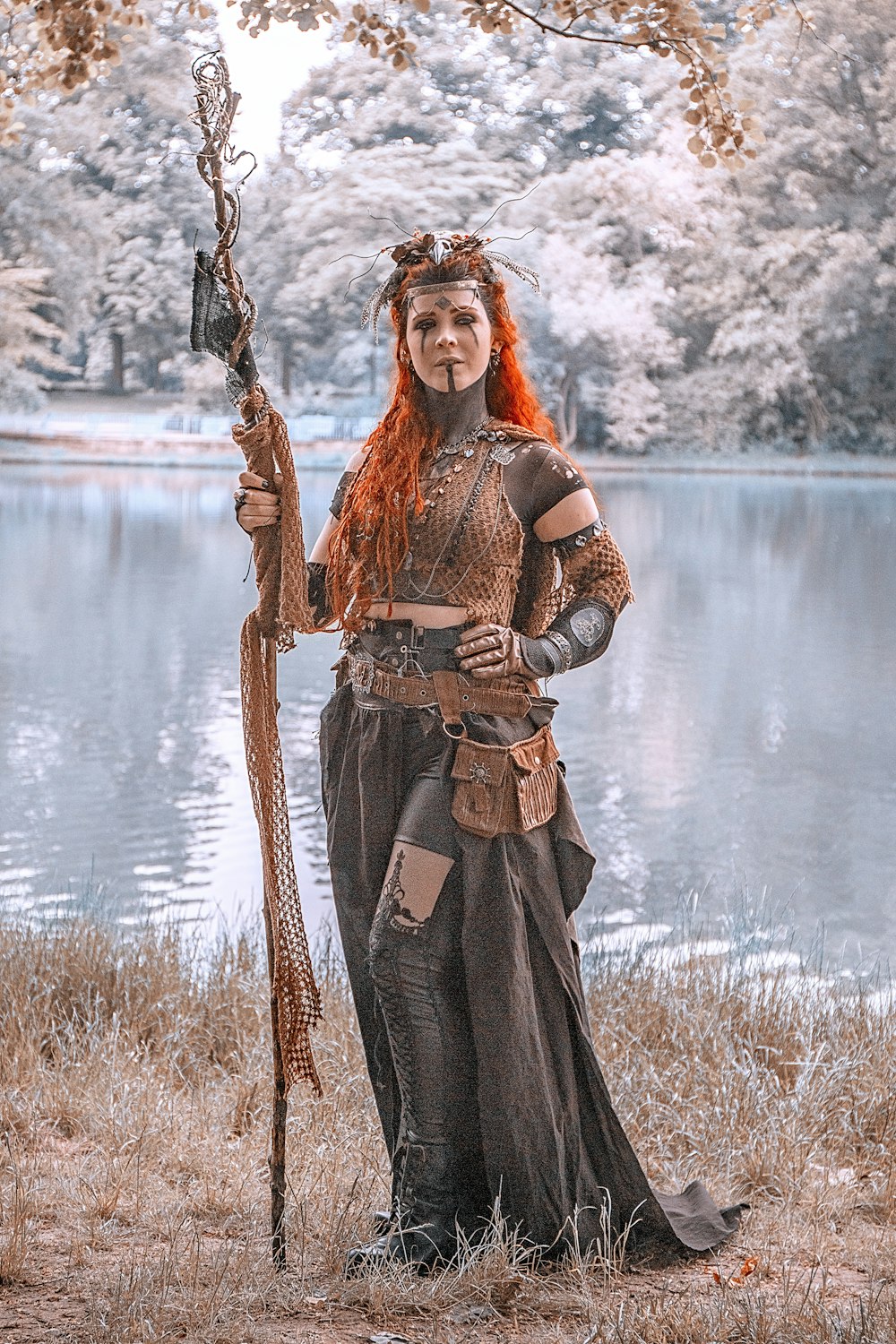 a woman with red hair is holding a stick