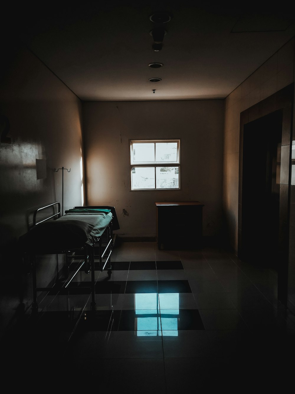 a dimly lit room with a bed and a window