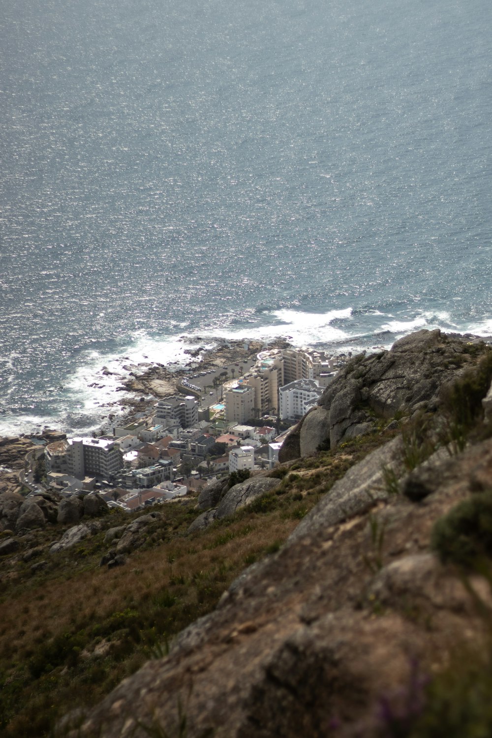 a man standing on top of a cliff next to the ocean