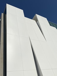 A contemporary house framed with clean, white SIP panels under a bright blue sky.