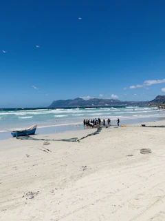 a group of people standing on top of a sandy beach