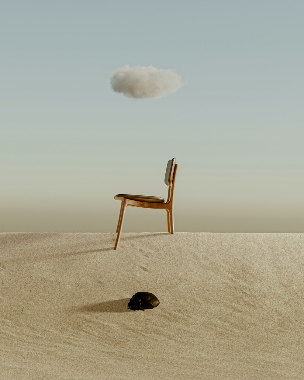une chaise assise au sommet d’une colline de sable