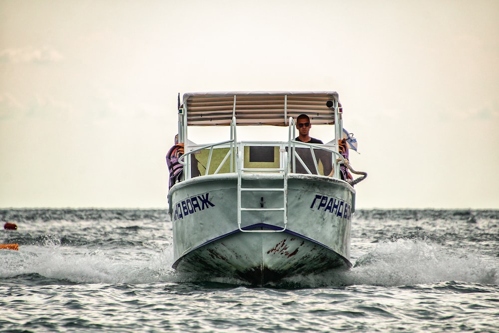 a white boat with people on it in the water