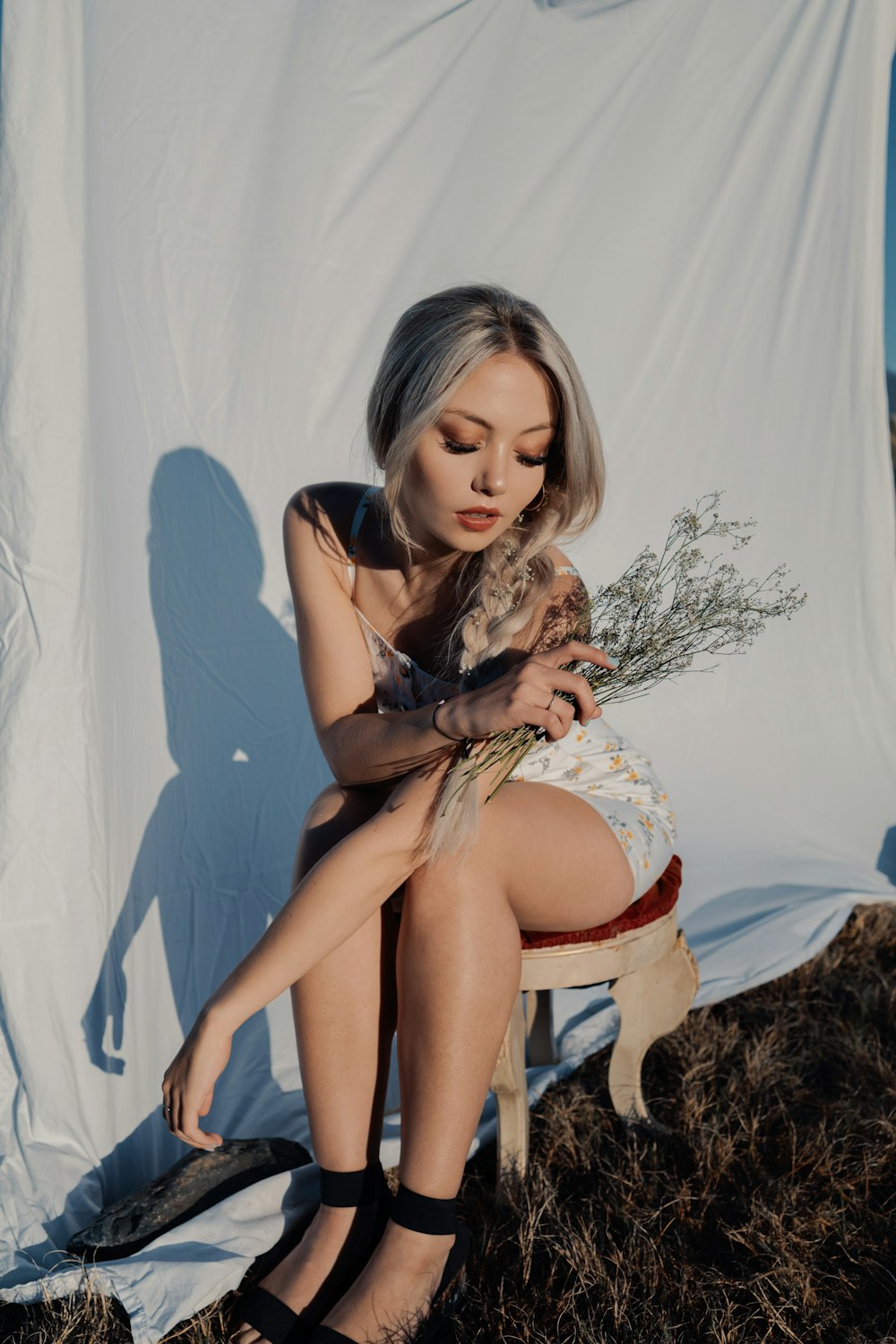 a woman sitting on a chair holding a cat