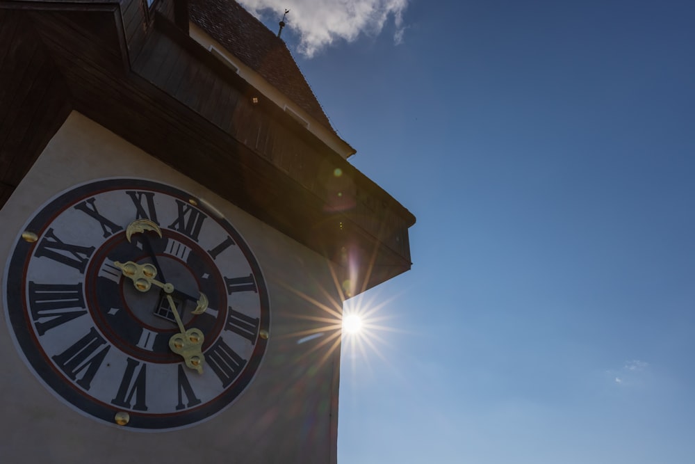 a clock tower with the sun shining behind it