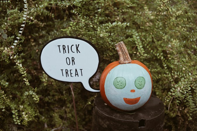 Painted Halloween pumpkin next to a trick or treat sign, a nod to the free trunk-or-treat at Hollywood Recreation Center on Oct. 24