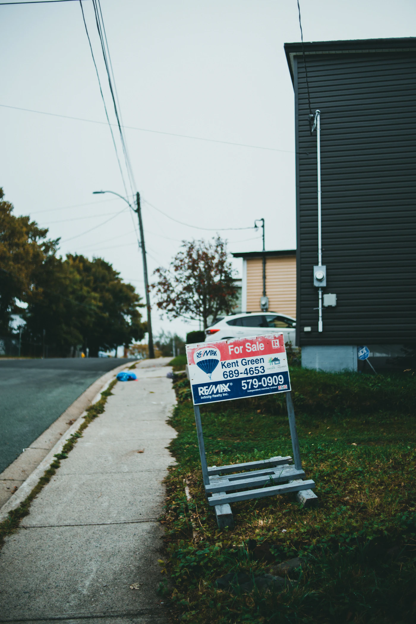 A for sale sign standing beside a road