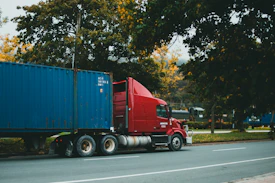 a red semi truck driving down a street