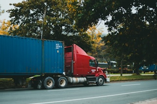 a red semi truck driving down a street