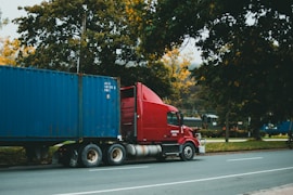 a red semi truck driving down a street