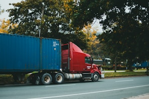 a red semi truck driving down a street