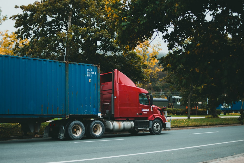 a red semi truck driving down a street