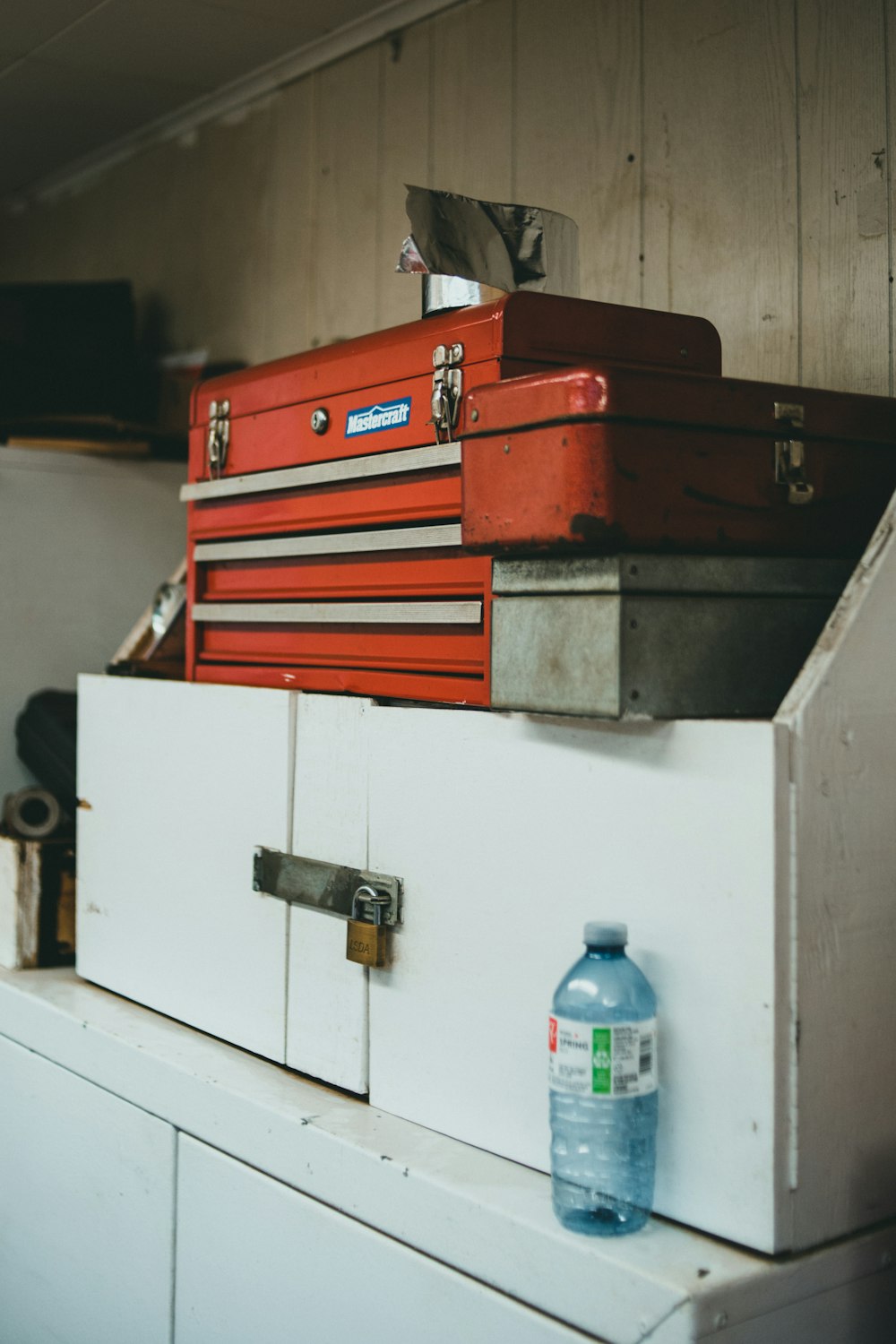 a red toolbox sitting on top of a white cabinet