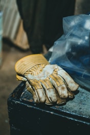 a pair of gloves sitting on top of a trash can
