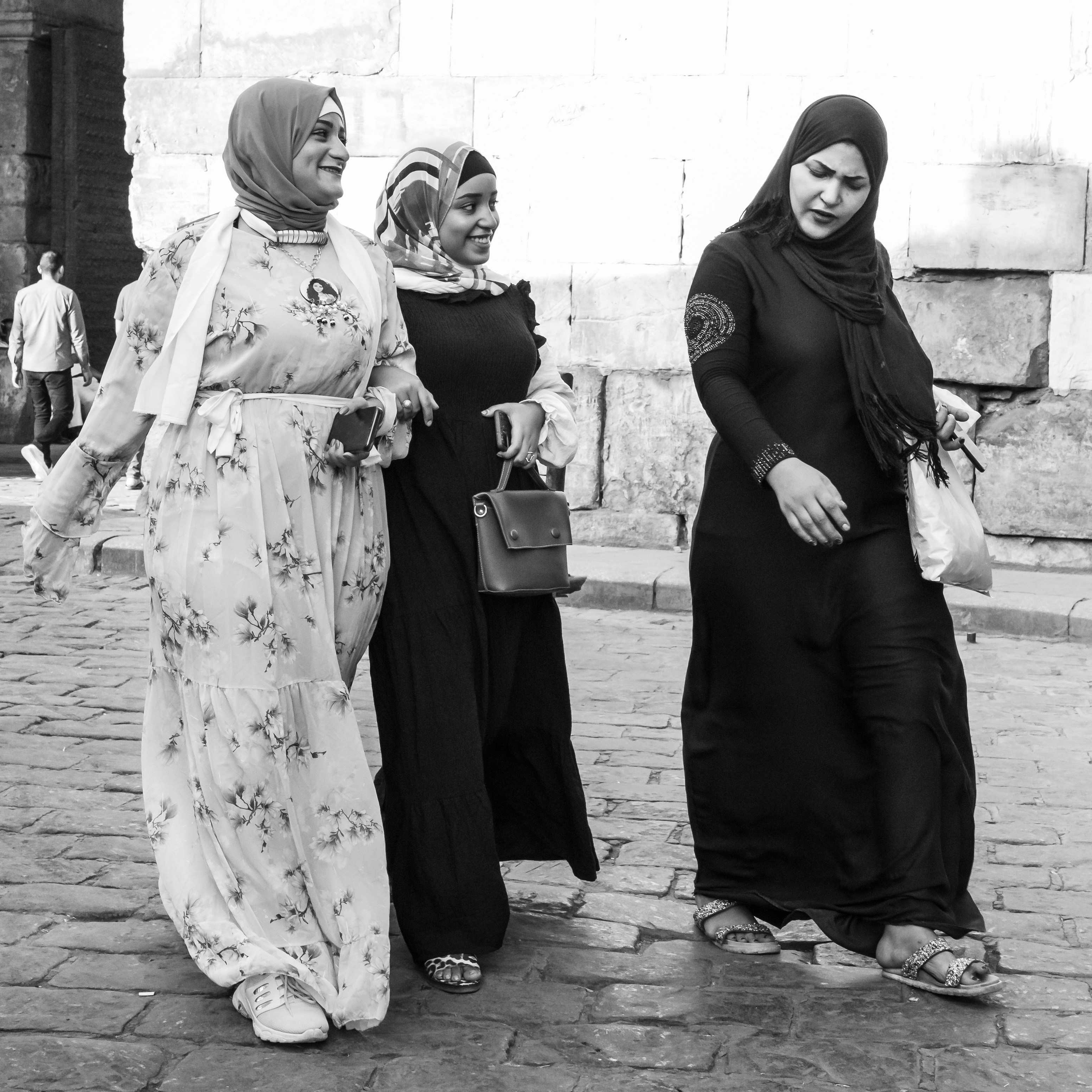 sekelompok wanita berjalan di jalan bersebelahan satu sama lain
