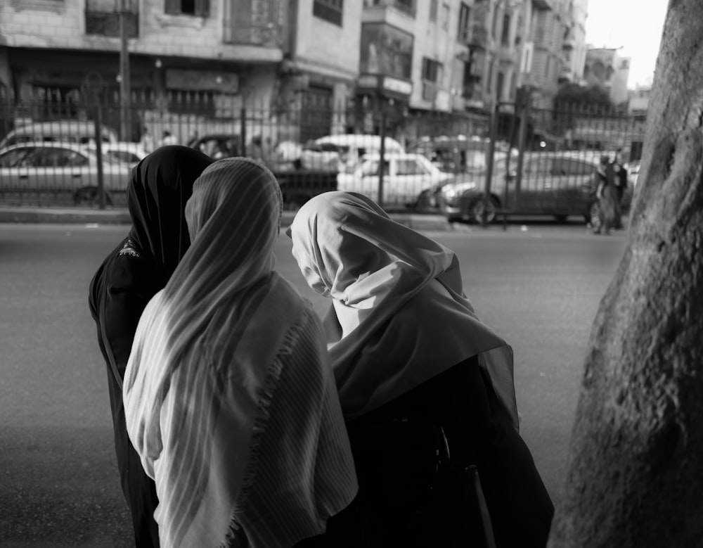 three women are walking down the street together