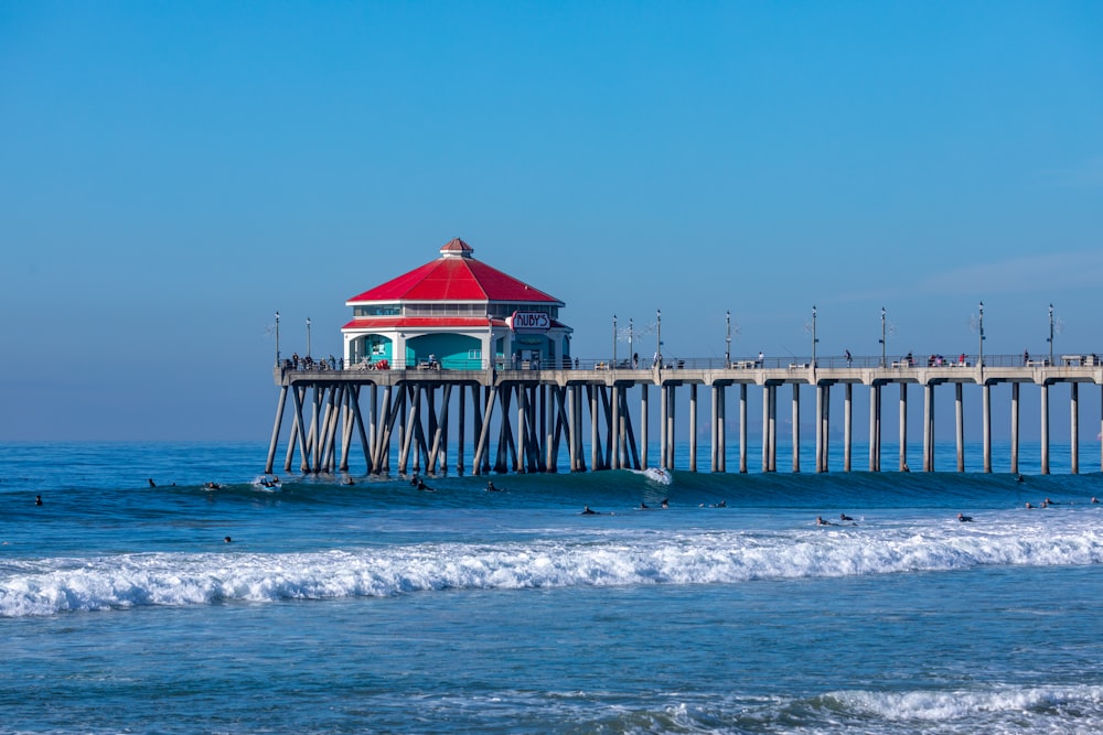 a red and white building sitting on top of a pier