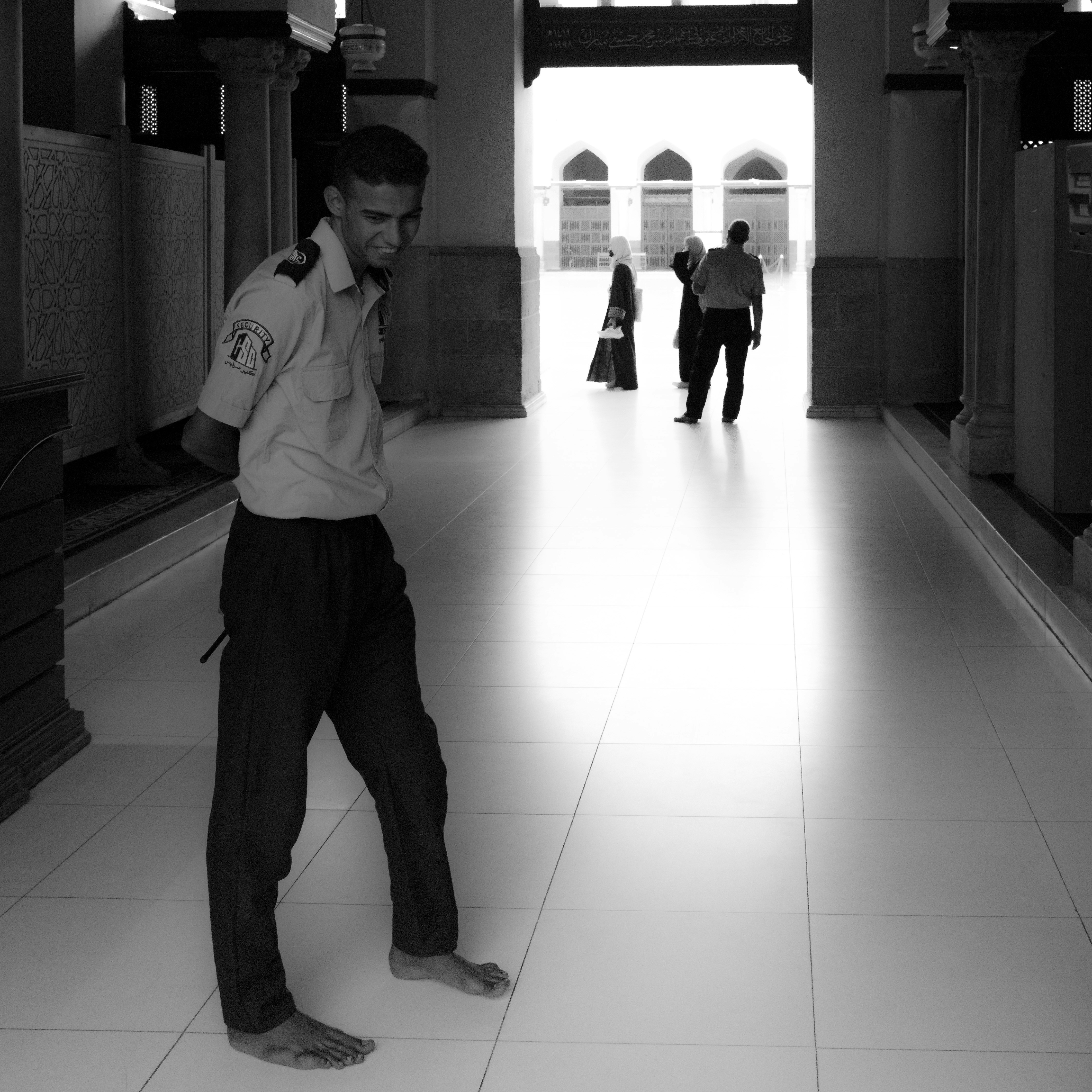 a man standing in a hallway talking on a cell phone