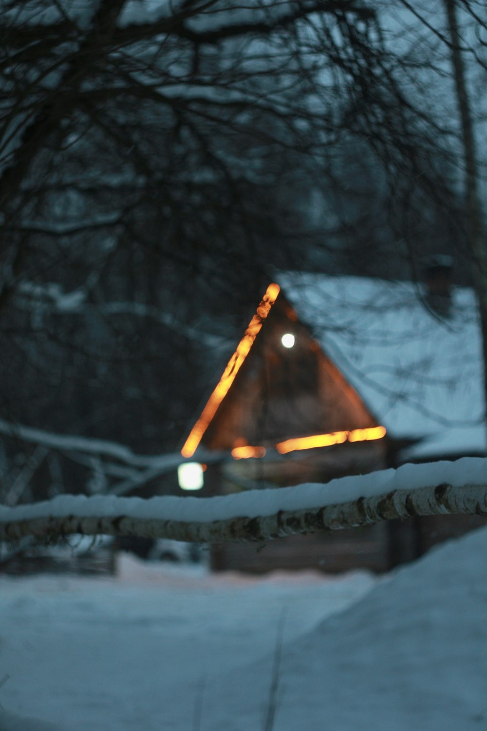 a house in the snow with a light on