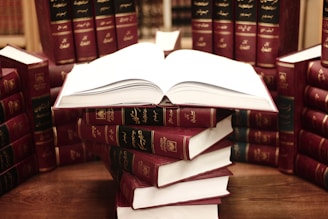 a stack of books sitting on top of a wooden table