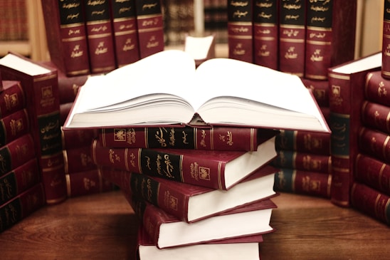 a stack of books sitting on top of a wooden table