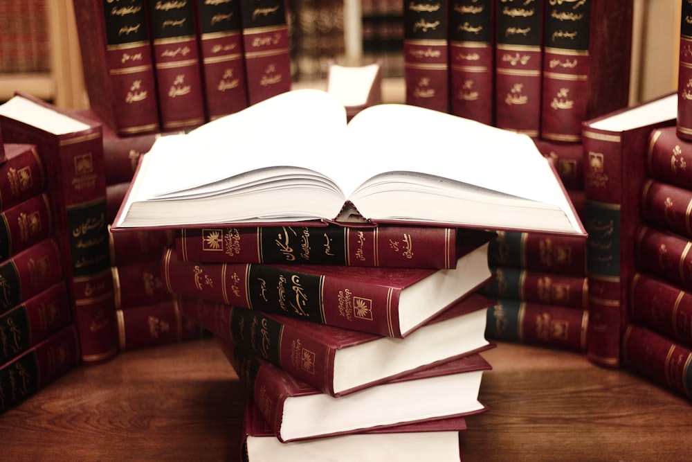 a stack of books sitting on top of a wooden table