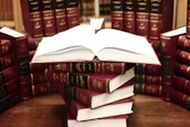 a stack of books sitting on top of a wooden table