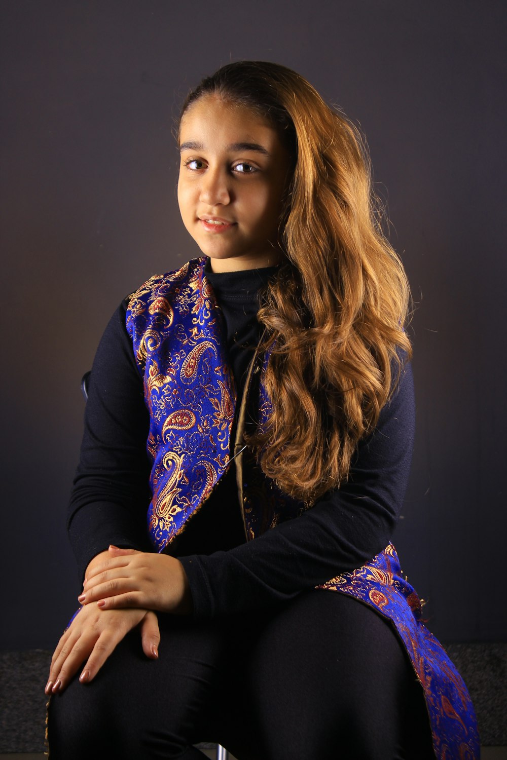 a woman with long hair sitting on a chair