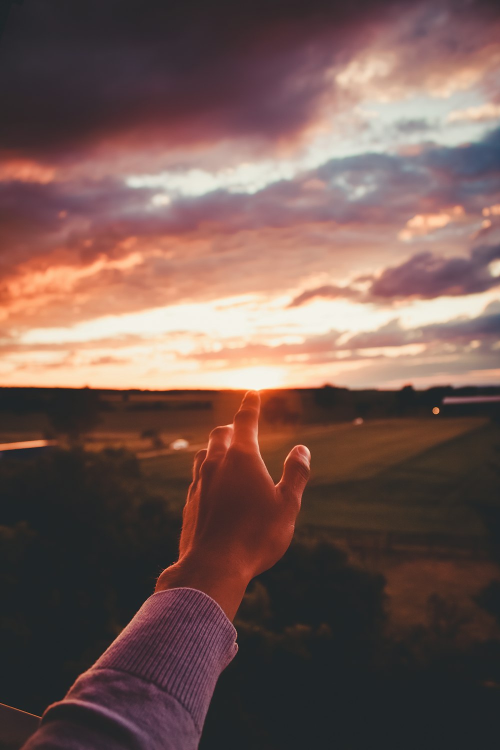 Eine Person hält ihre Hand in den Himmel