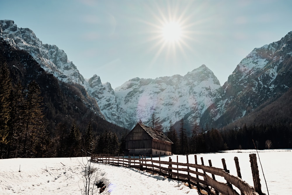 the sun is shining over a snowy mountain range