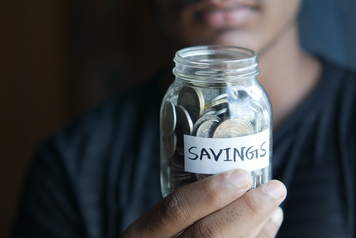 Person holding a savings jar representing retirement savings goals