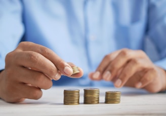 a person stacking coins on top of a table