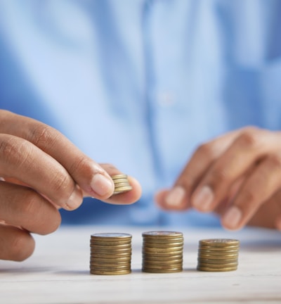 a person stacking coins on top of a table