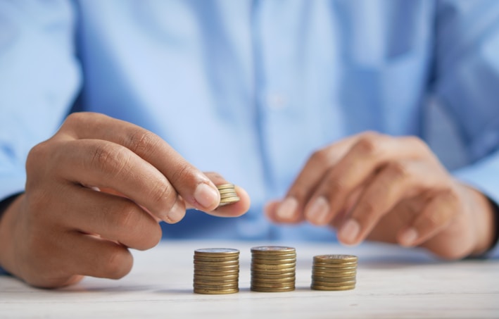 a person stacking coins on top of a table