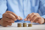 a person stacking coins on top of a table