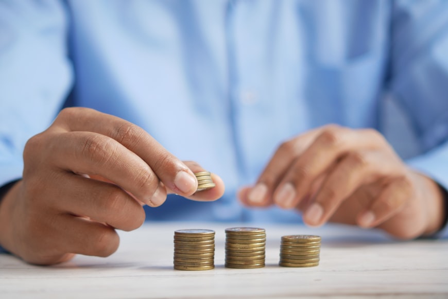 A hand lifting up stackable coins 