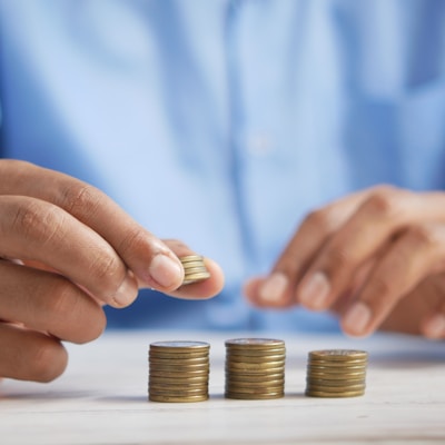 a person stacking coins on top of a table