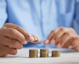 a person stacking coins on top of a table