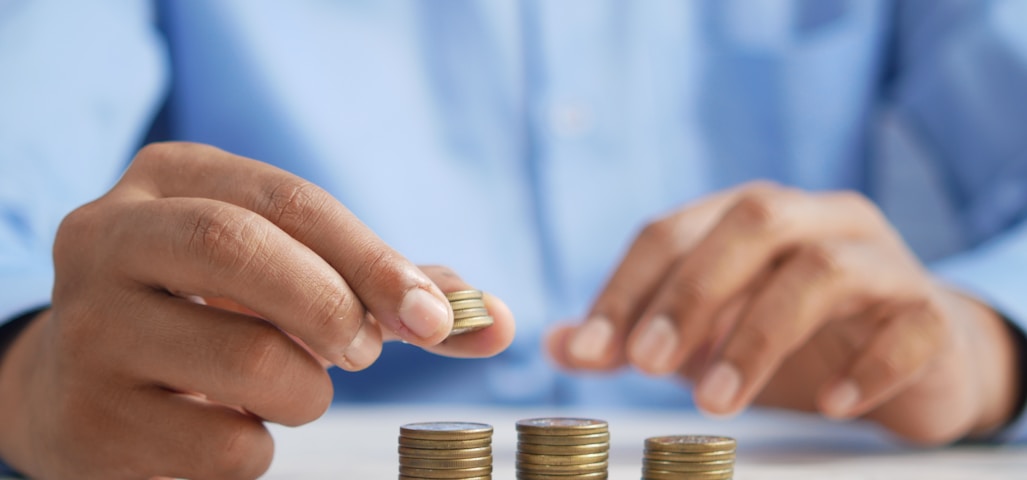 a person stacking coins on top of a table