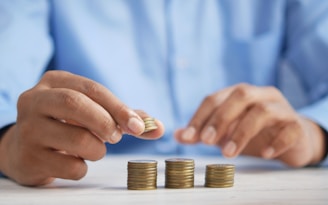 a person stacking coins on top of a table