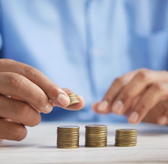 a person stacking coins on top of a table