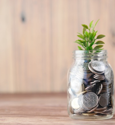 a glass jar filled with coins and a plant