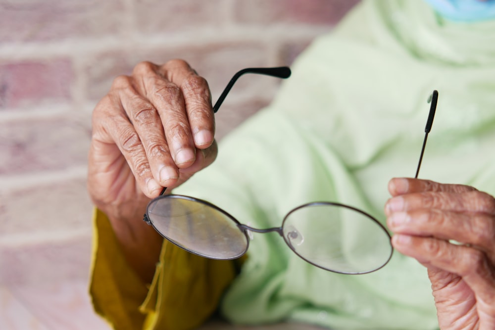 Una anciana sosteniendo un par de gafas