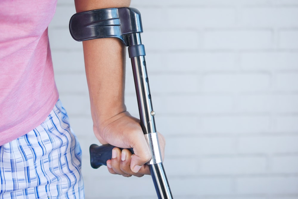 a person holding a crutch and walking cane