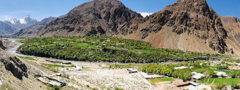 a valley surrounded by mountains with a river running through it