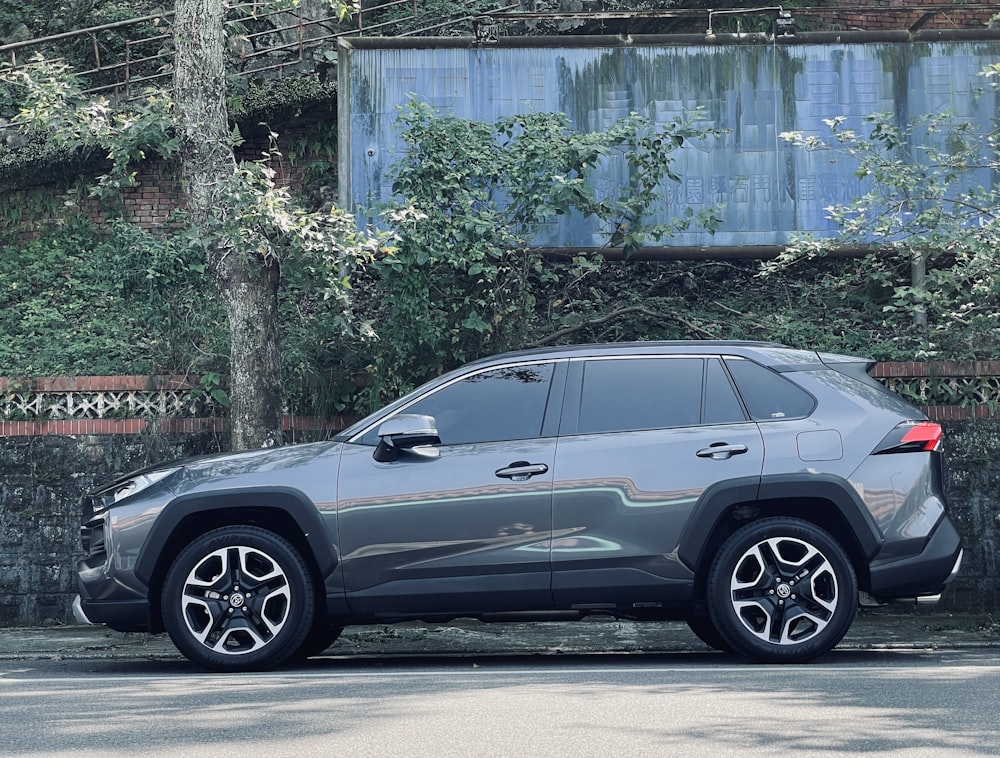 a grey suv parked on the side of the road