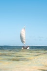 a sailboat with two people on it in the ocean
