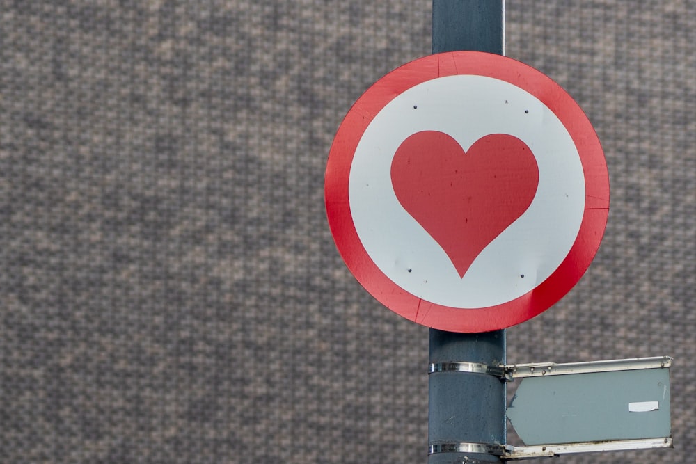a red and white sign with a heart on it